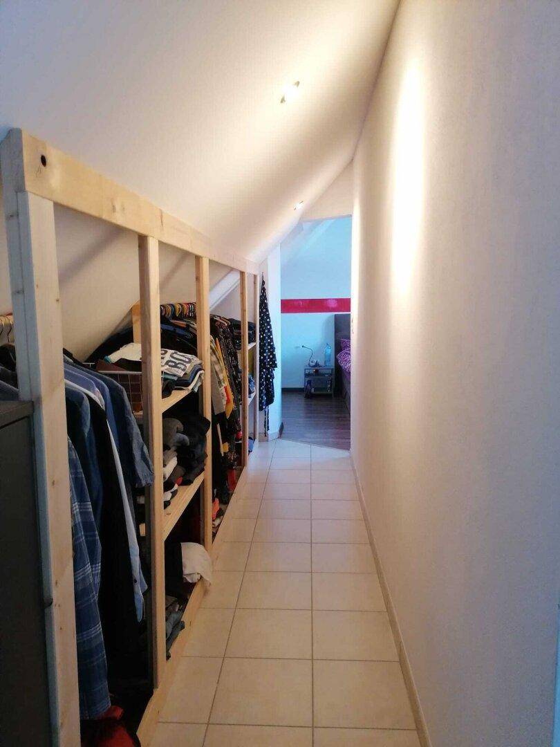 Dachgeschossflur mit offener Kleideraufbewahrung und schrägen Wänden.