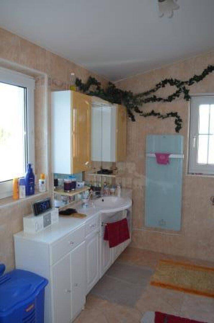 Badezimmer mit Waschbecken, Spiegelschrank und beheiztem Handtuchhalter.