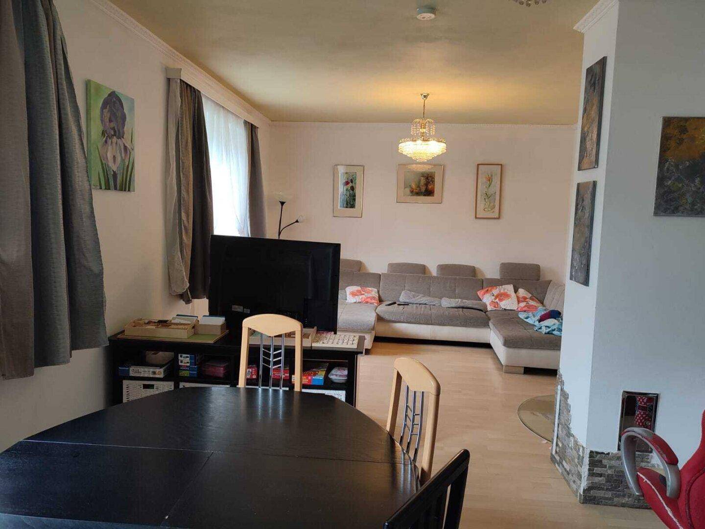 Gemütlicher Wohn- und Essbereich mit Ecksofa, Esstisch und Kamin im Hintergrund.