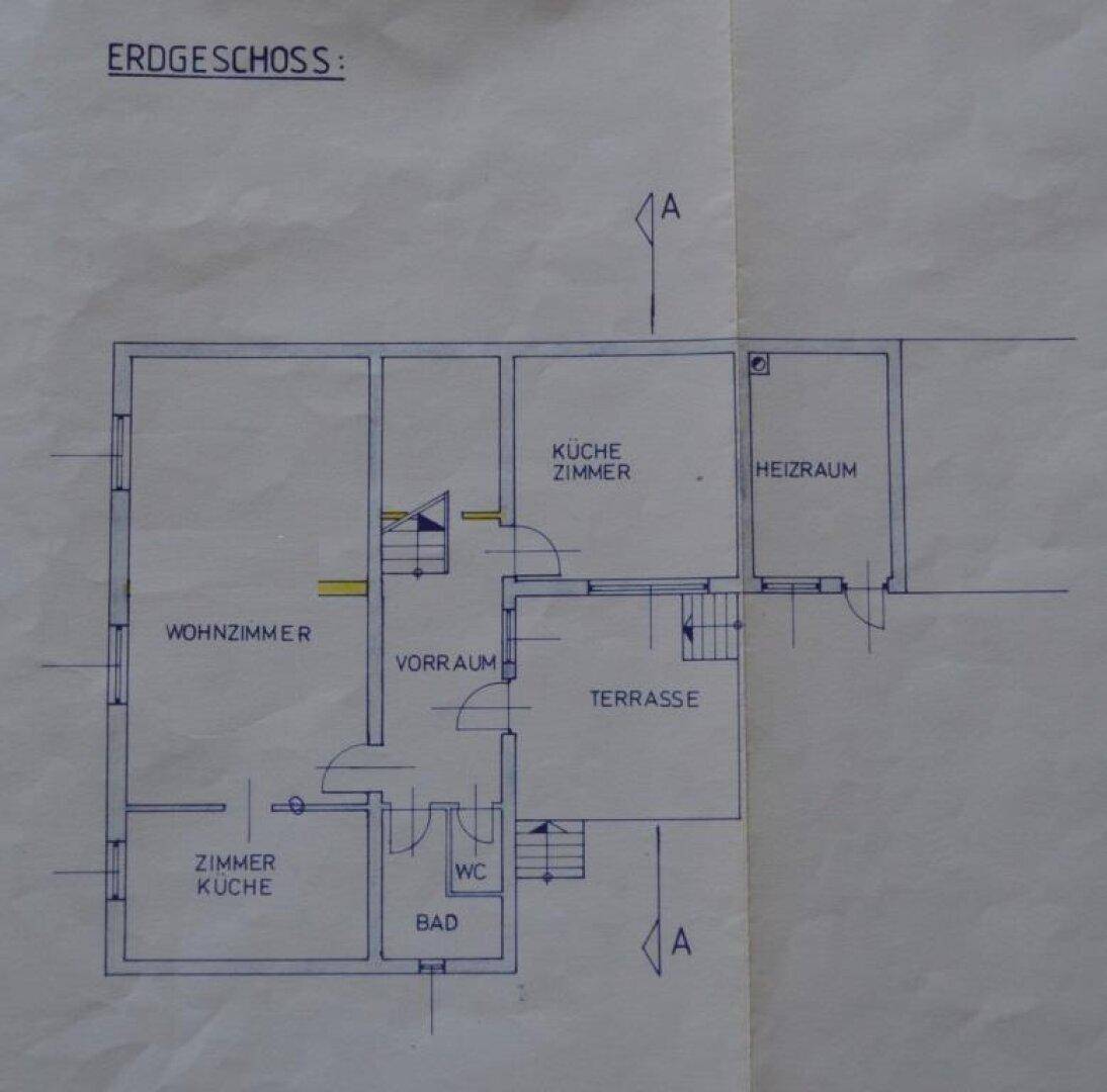 Grundriss des Erdgeschosses zeigt Wohnzimmer, separate Küche, Bad, WC und eine zugängliche Terrasse.
