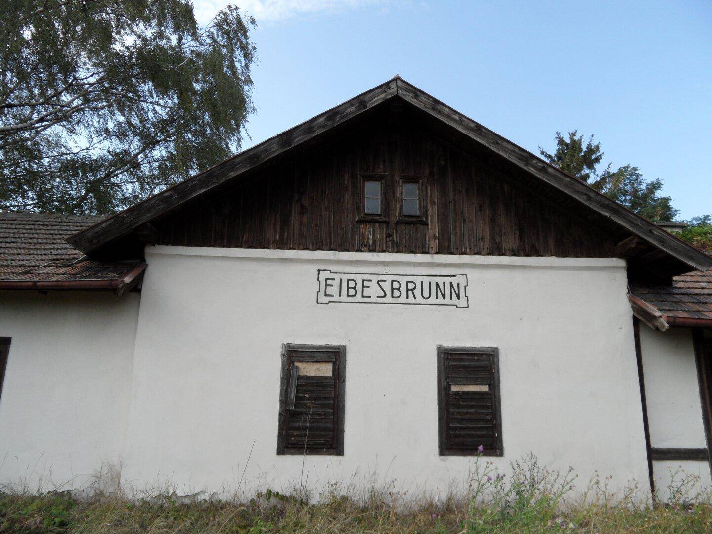 Altes Gebäude mit rustikaler Holzverkleidung und dem Schriftzug 'EIBESBRUNN' an der Fassade.