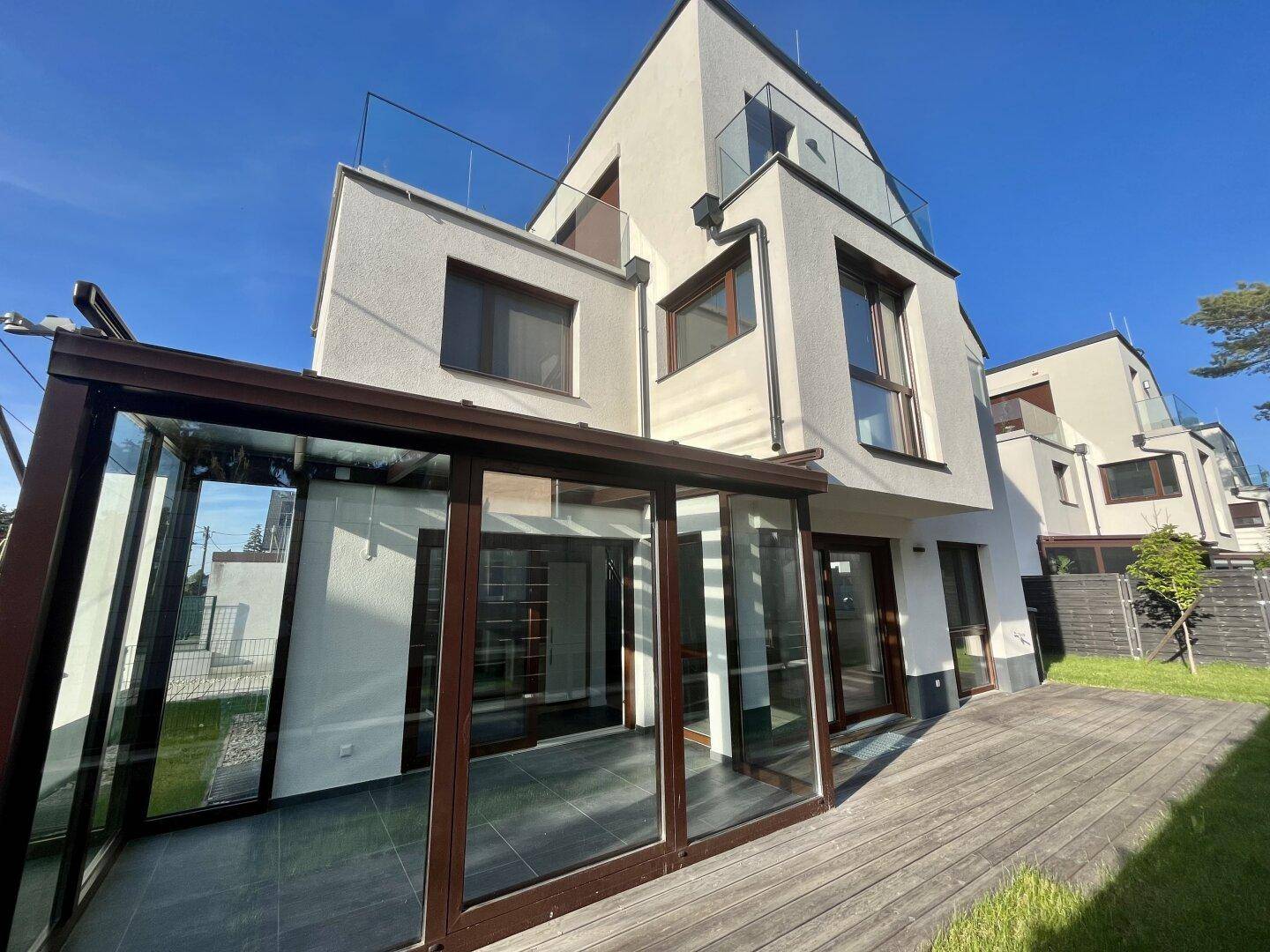 Moderne Architektur des Hauses mit Wintergarten, Holzterrasse und Dachterrassen.