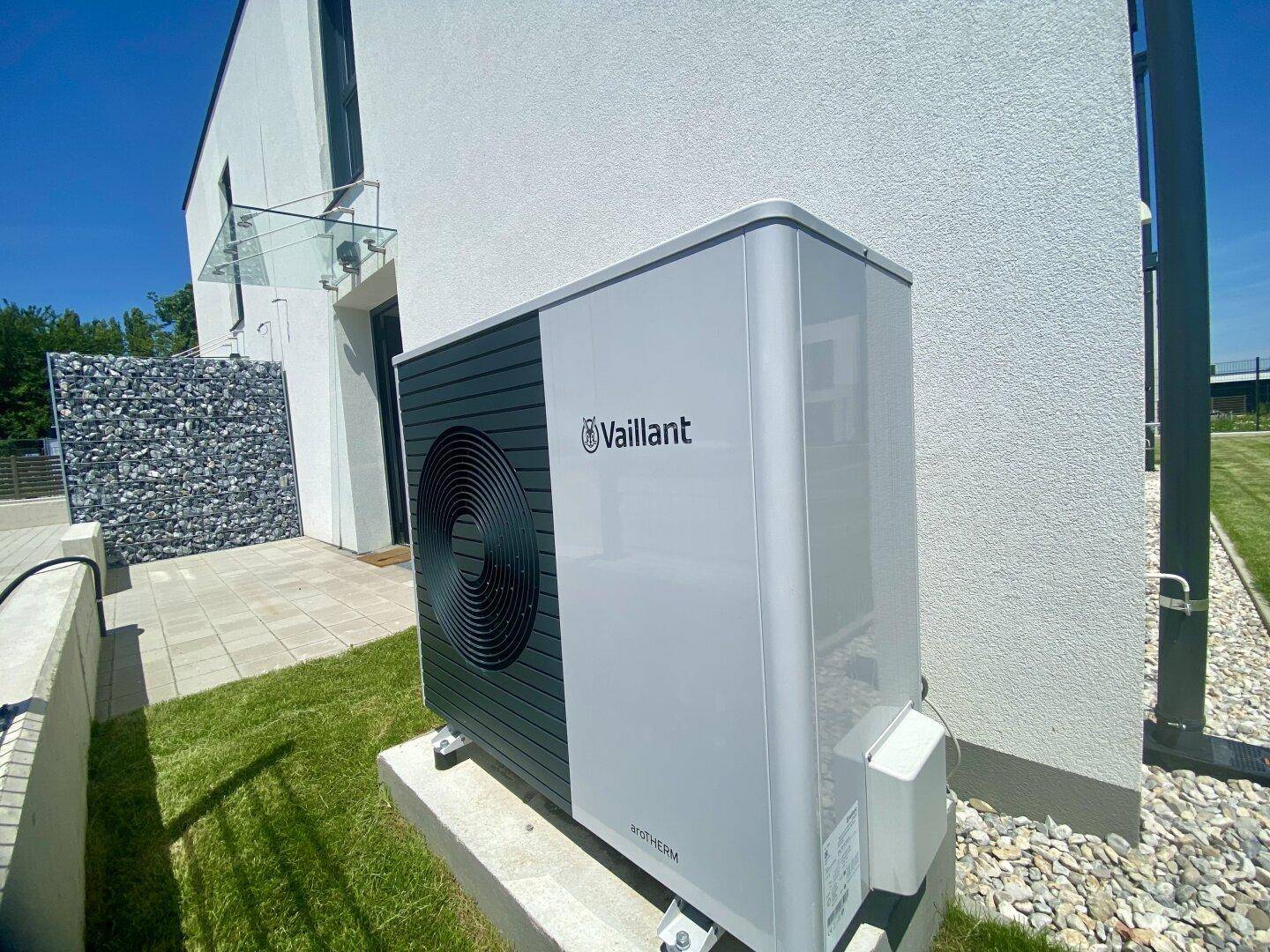 Moderne Vaillant Wärmepumpe an der Außenwand eines Neubaus installiert.