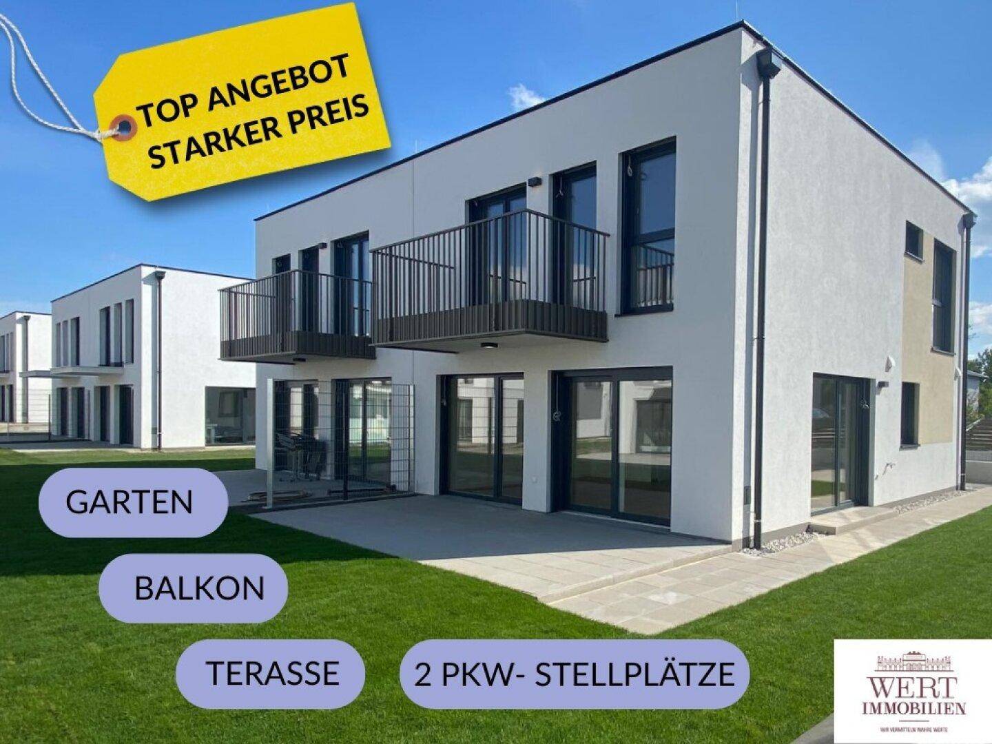 Modernes Doppelhaus mit weißer Fassade, Balkonen und einer gepflegten Rasenfläche unter blauem Himmel.