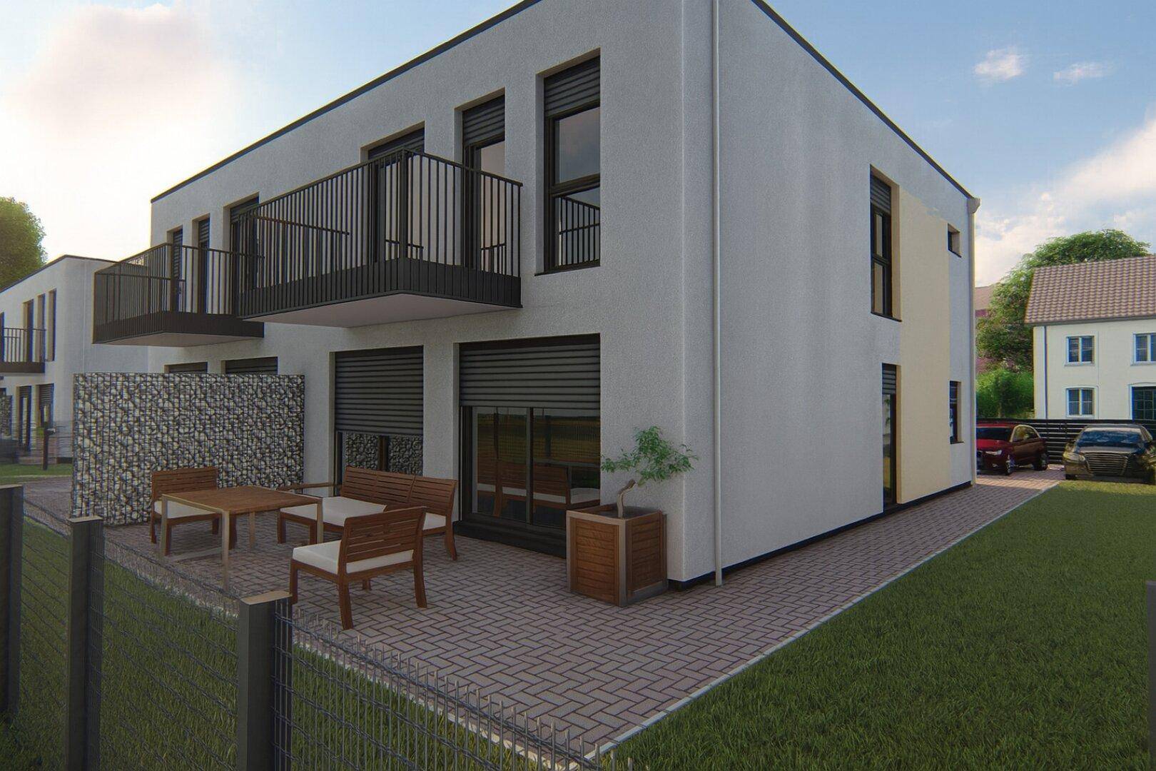 Gepflegte Terrasse mit Gartenmöbeln und Zugang zum Garten, ergänzt durch Balkone im Obergeschoss.