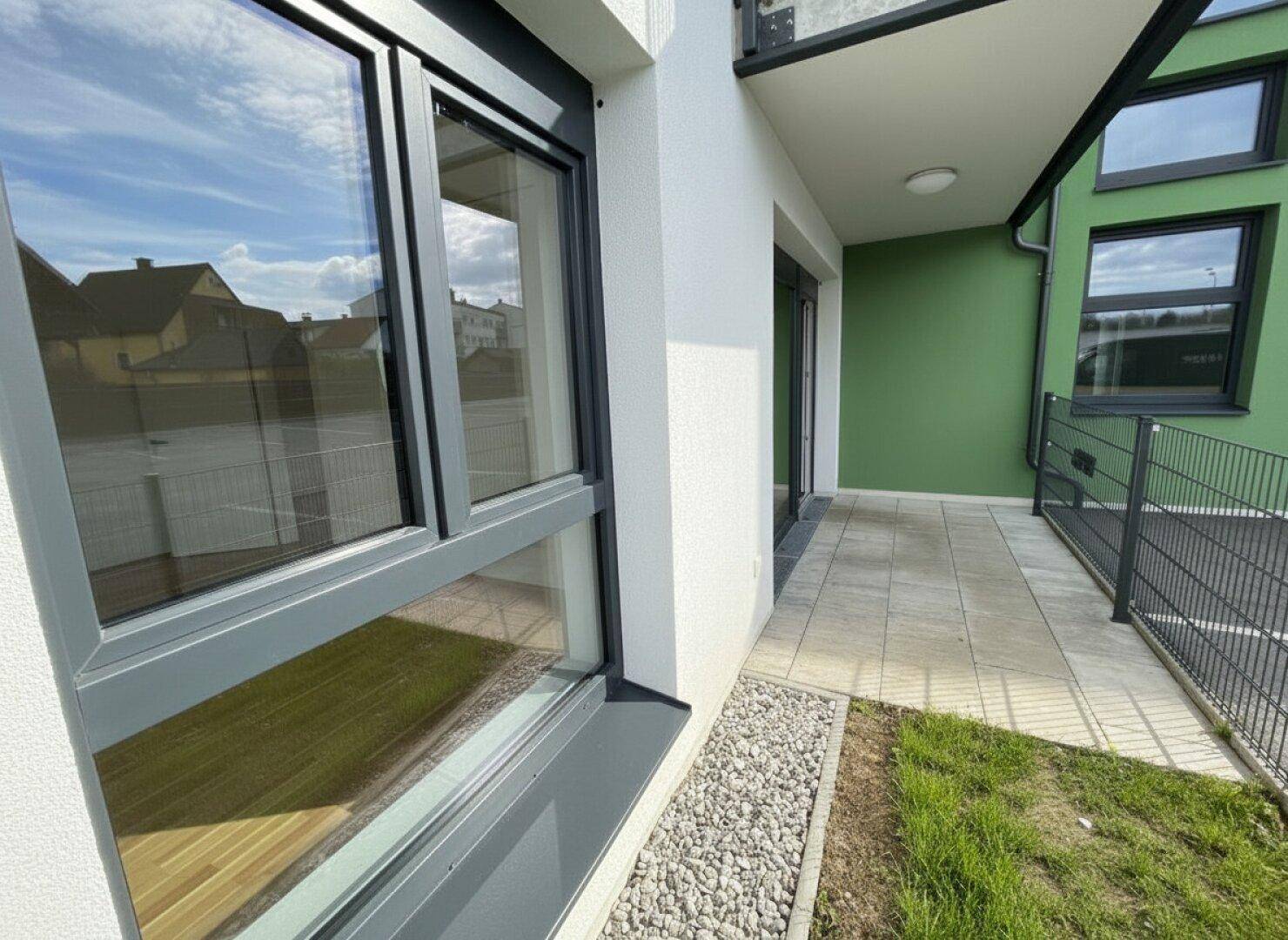 Gepflasterte Terrasse am Gebäude mit Zugang zum Gartenbereich.