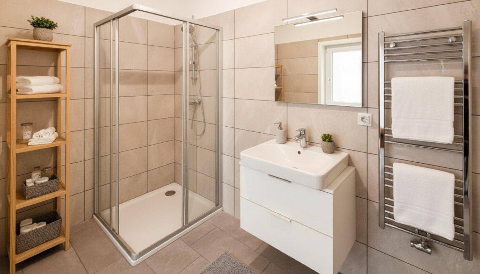 Modernes Badezimmer mit Duschkabine, Waschtisch und beheiztem Handtuchhalter.