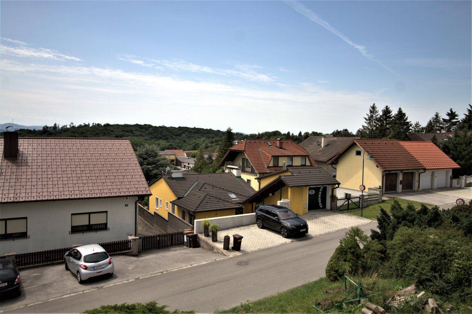 Blick über eine Wohnsiedlung mit Einfamilienhäusern und grüner Umgebung.
