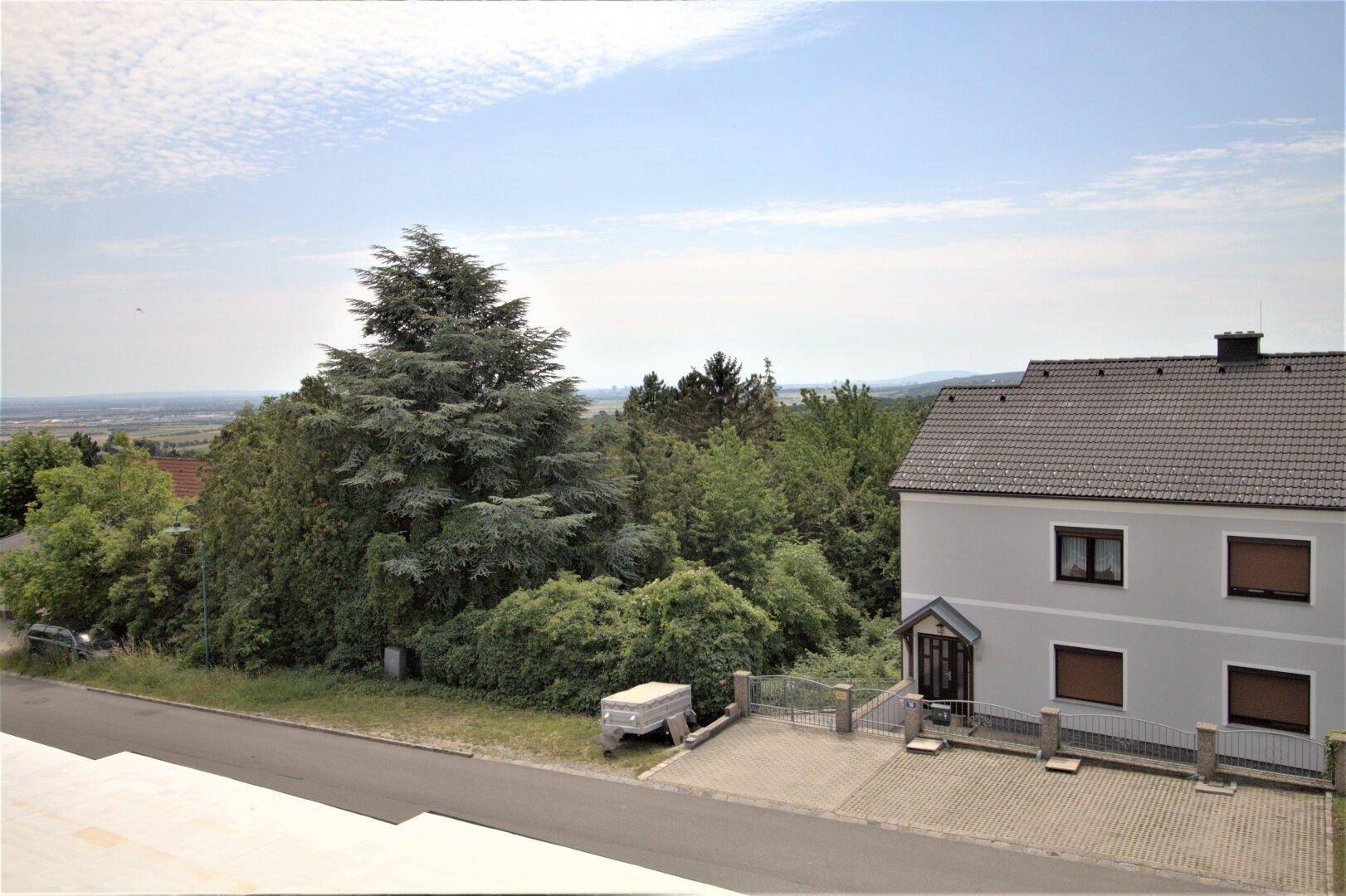 Haus mit gepflasterter Einfahrt und weitem Blick über die Landschaft.