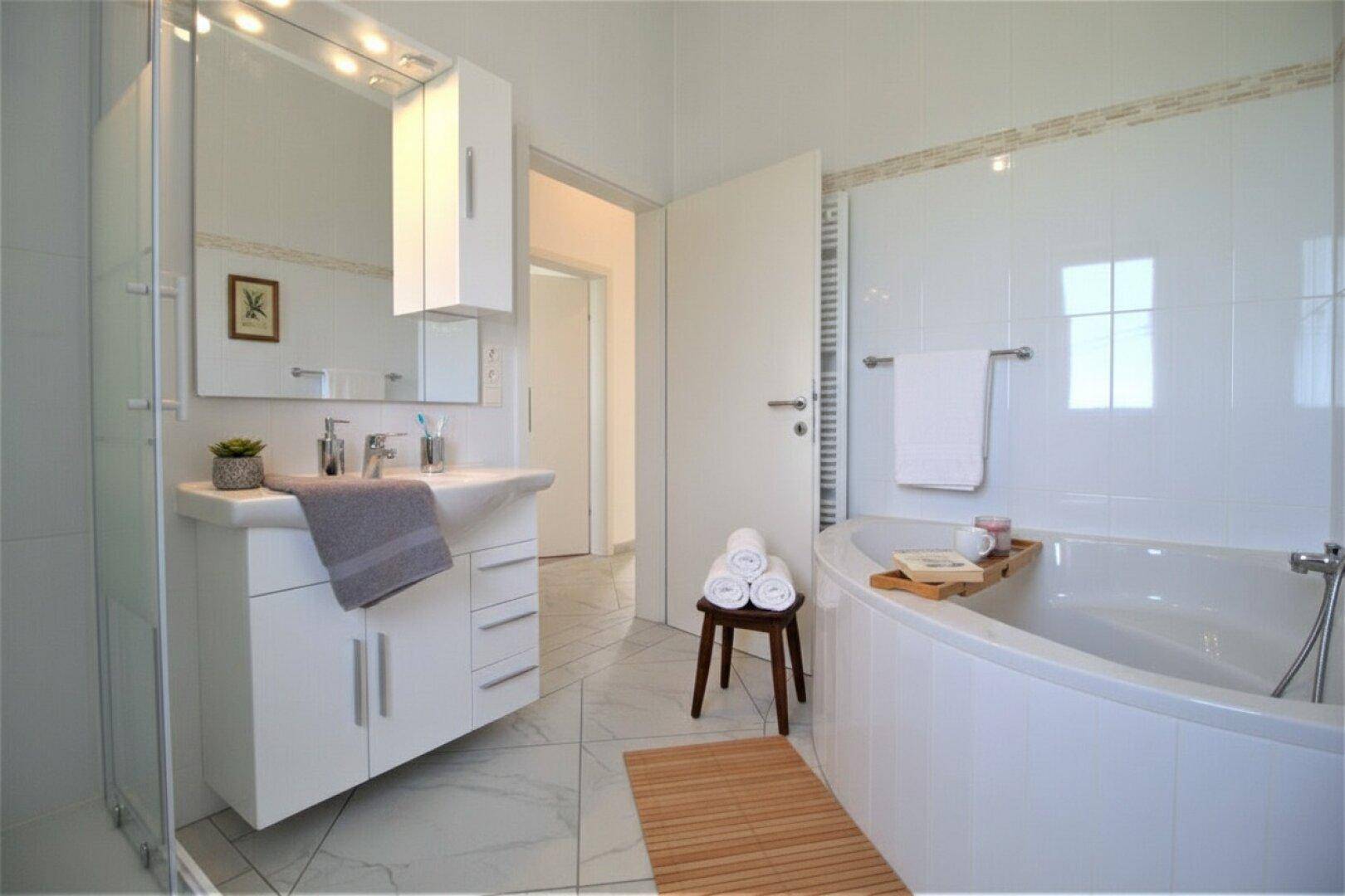 Modernes Badezimmer mit Badewanne, Dusche und Waschtisch mit Spiegelschrank.