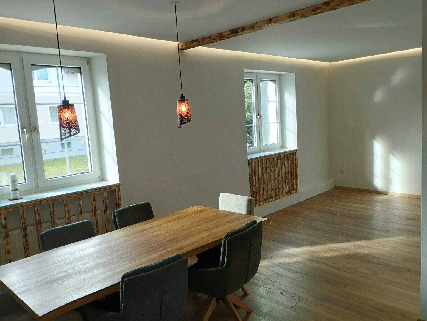 Moderner Essbereich mit Holztisch, Designerstühlen und indirekter Deckenbeleuchtung.