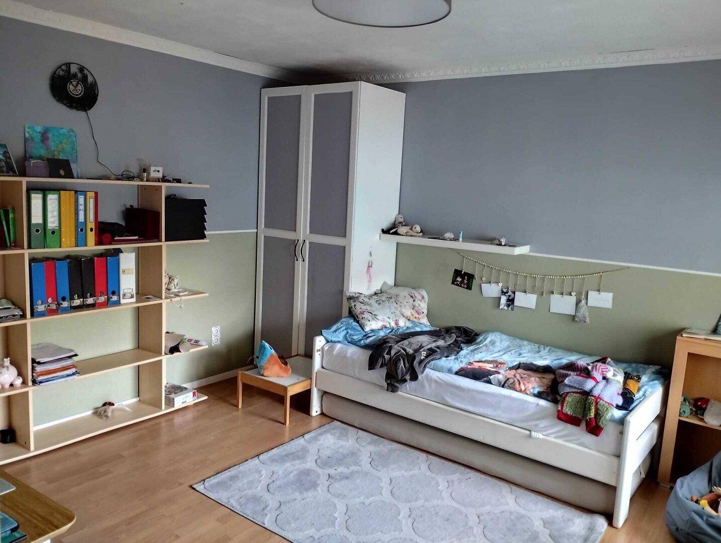 Helles Kinderzimmer mit Einzelbett, Regal und Stauraum, ideal für junge Bewohner.