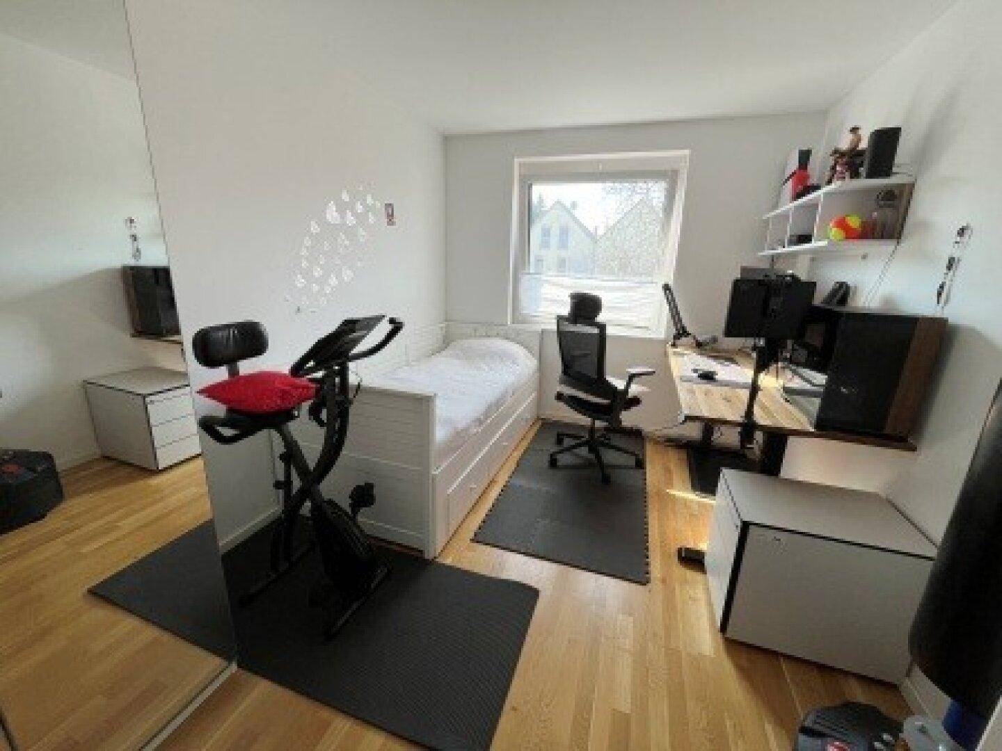 Vielseitiges Zimmer mit Einzelbett, Schreibtisch und Heimtrainer, perfekt als Gäste- oder Arbeitszimmer.
