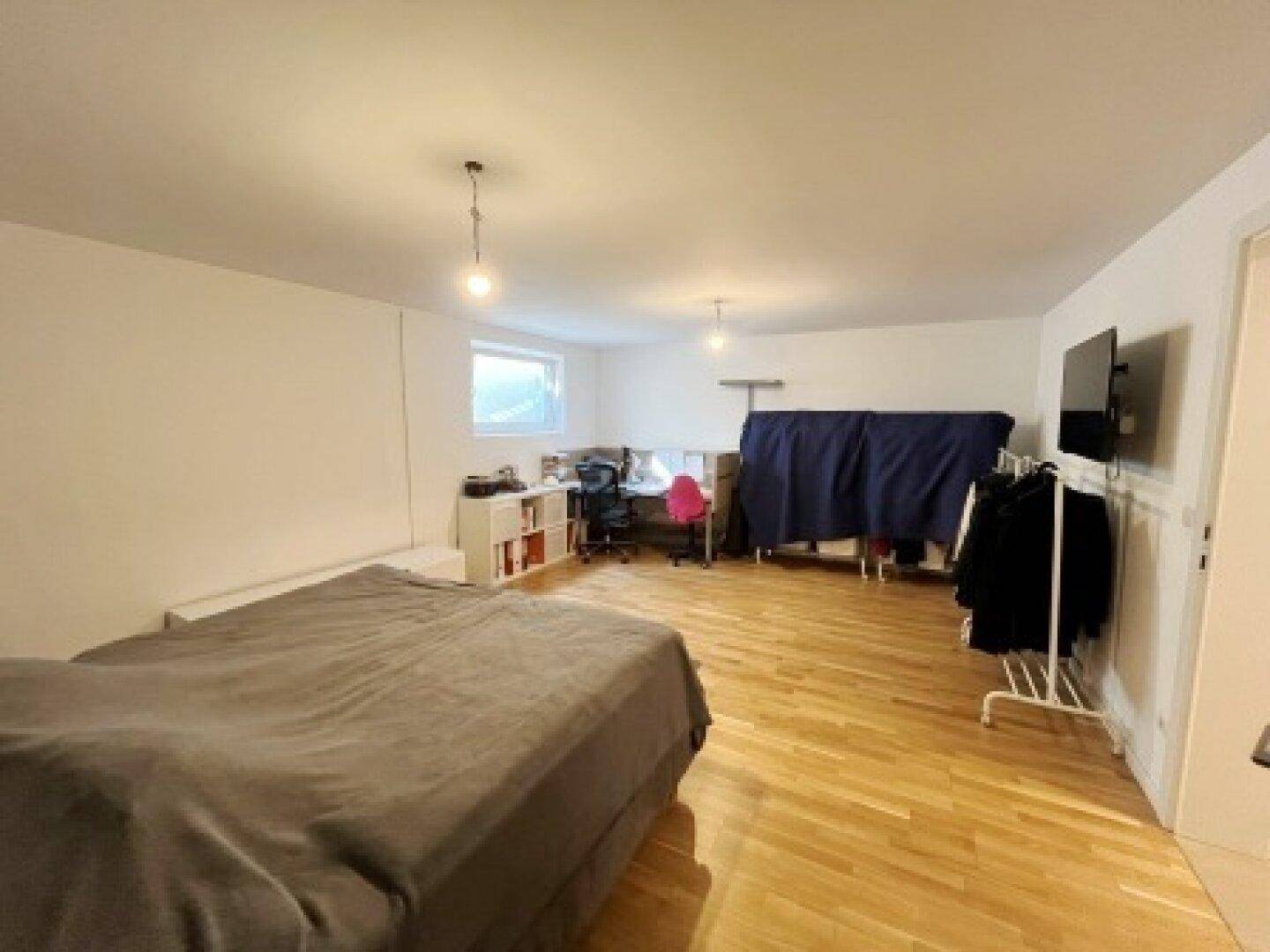 Großes Schlafzimmer mit Holzboden, Doppelbett und viel Platz für individuelle Gestaltungsmöglichkeiten.