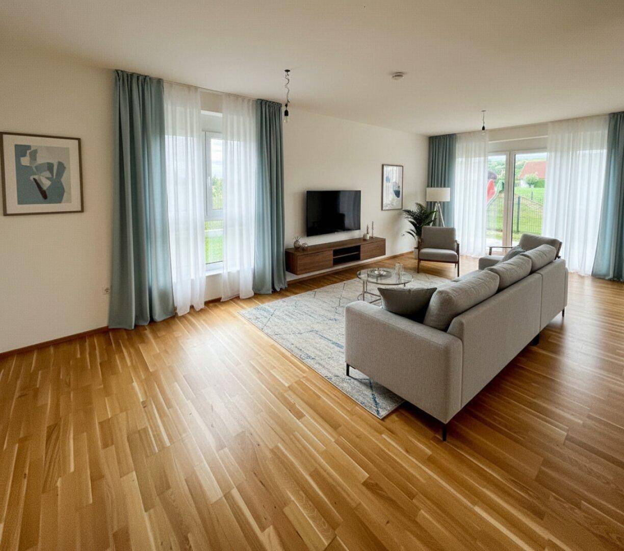 Gemütliches Wohnzimmer mit Holzboden, modernen Möbeln und Blick ins Grüne durch große Fenster.