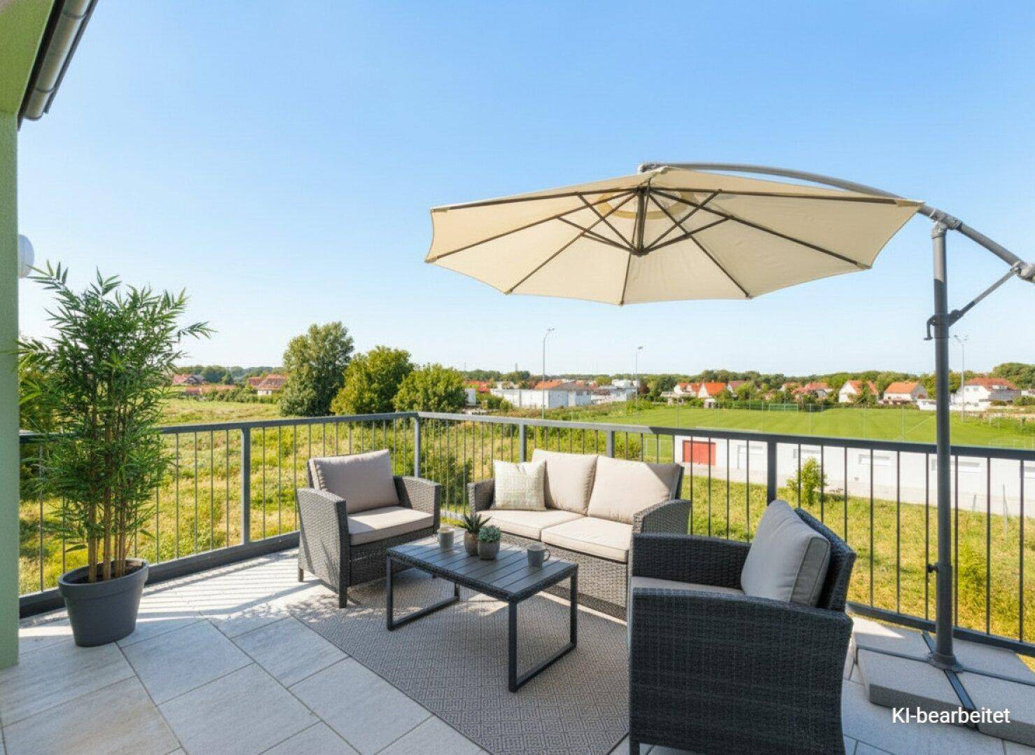 Möblierter Balkon mit Sitzgruppe und Sonnenschirm, ideal zum Entspannen im Freien.