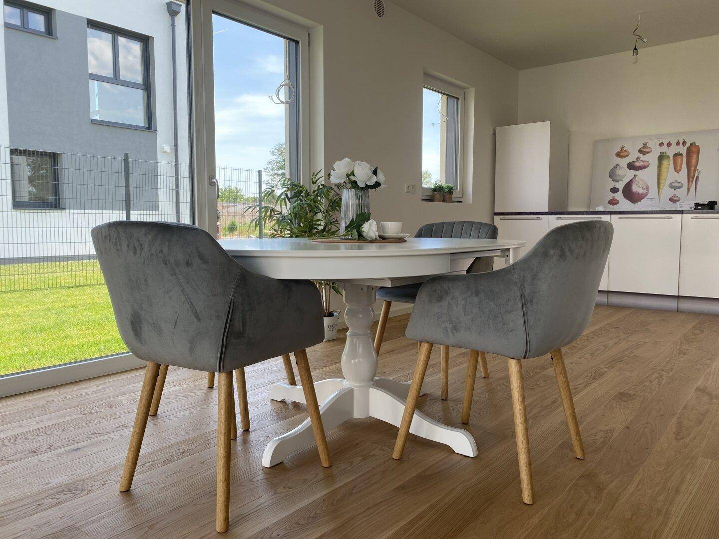 Heller Essbereich mit modernem Tisch und Stühlen, angrenzend an die Küche mit Gartenblick.