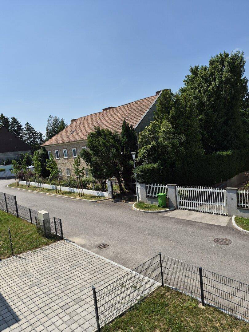 Weitblick auf ein charmantes altes Gebäude mit Ziegeldach und grüner Umgebung.