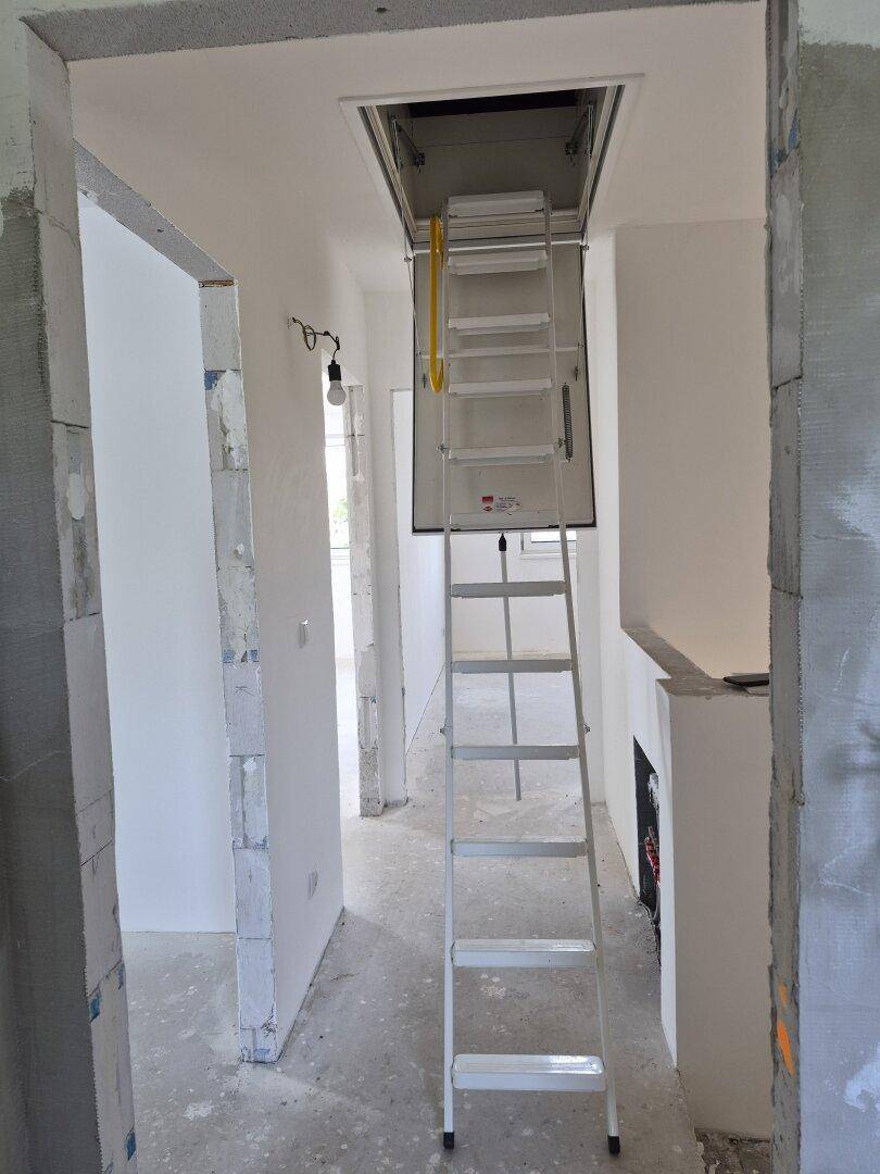 Flur mit ausziehbarer Dachbodenleiter, die Zugang zum oberen Bereich des Hauses bietet.