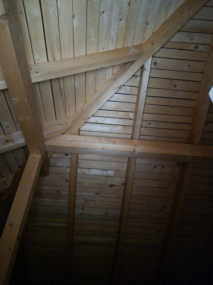 Dachboden mit sichtbaren Holzbalken und Holzverkleidung, bietet Ausbaupotenzial.