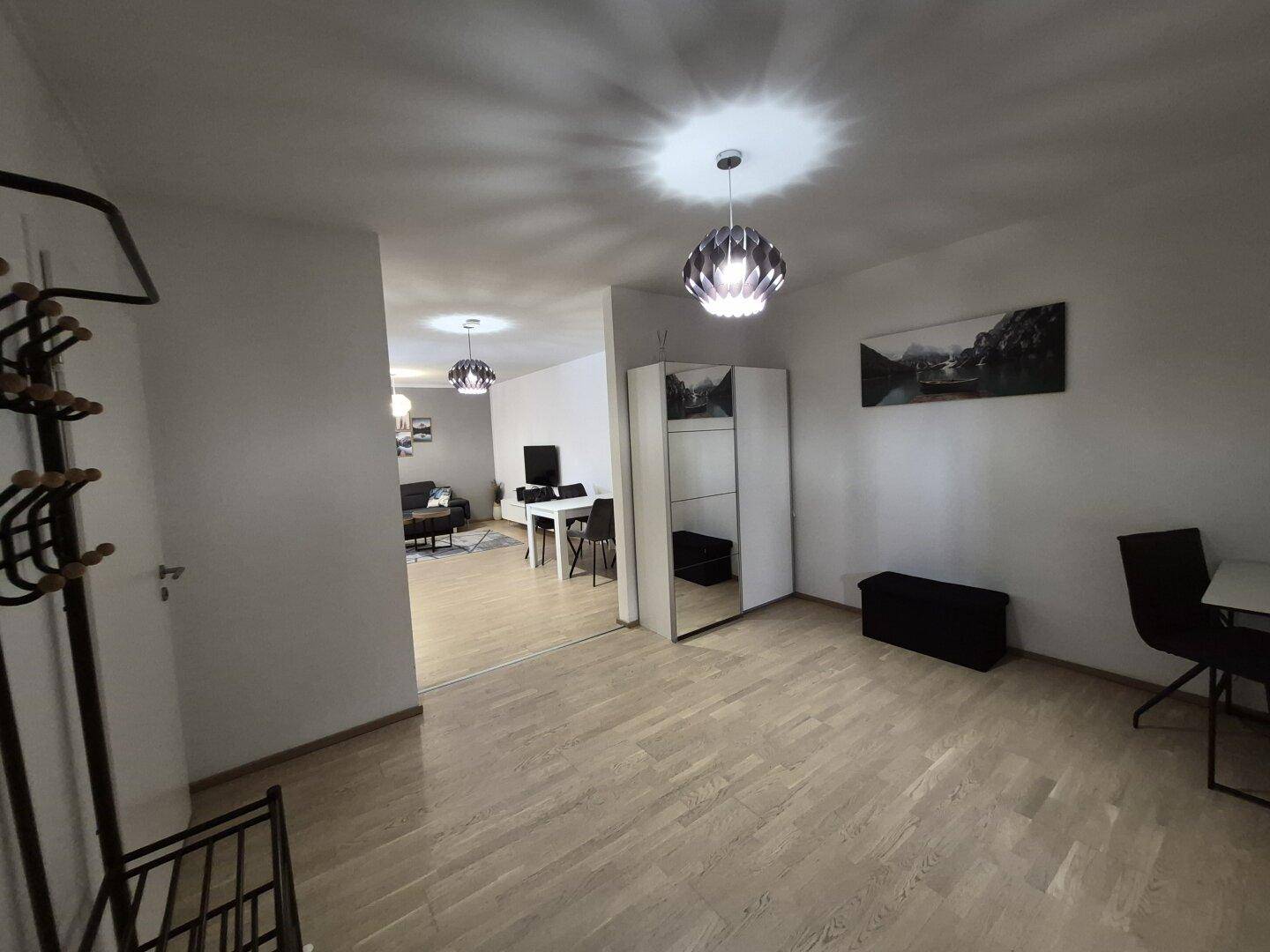 Geräumiger Flur mit Garderobe, Spiegel und Blick in den offenen Wohnbereich, hell und einladend.
