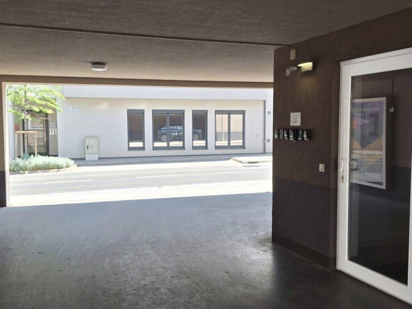 Überdachter Eingangsbereich oder Carport mit Blick auf die Straße und weitere Gebäude.
