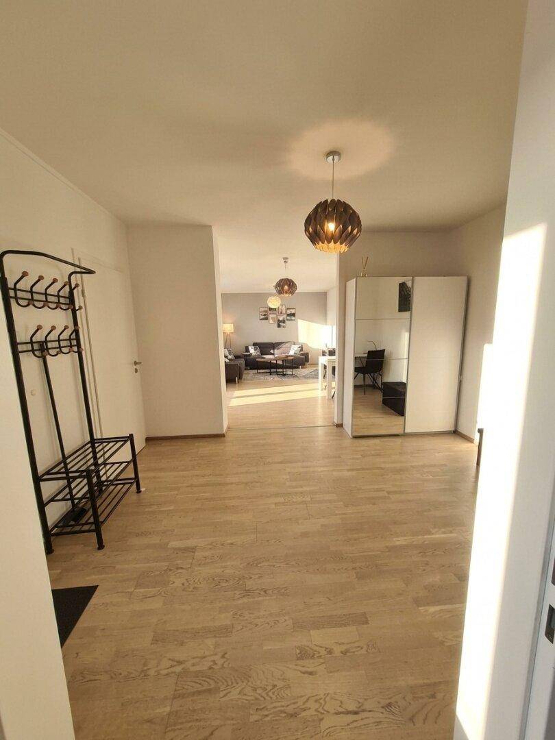Heller Eingangsbereich mit Garderobe und Blick in den sonnigen Wohnbereich.