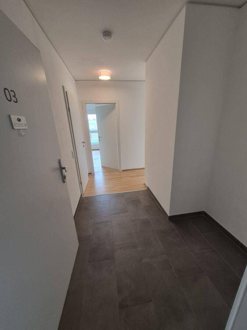 Eingangsbereich mit Fliesenboden und Zugang zu weiteren Räumen, gekennzeichnet mit Nummer 03.