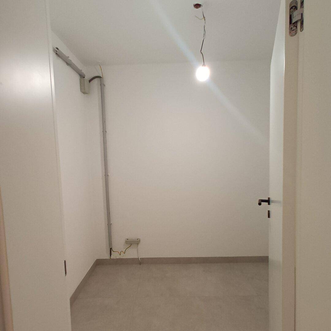 Kleiner Abstellraum mit einfacher Beleuchtung und Fliesenboden, praktisch für Lagerung.