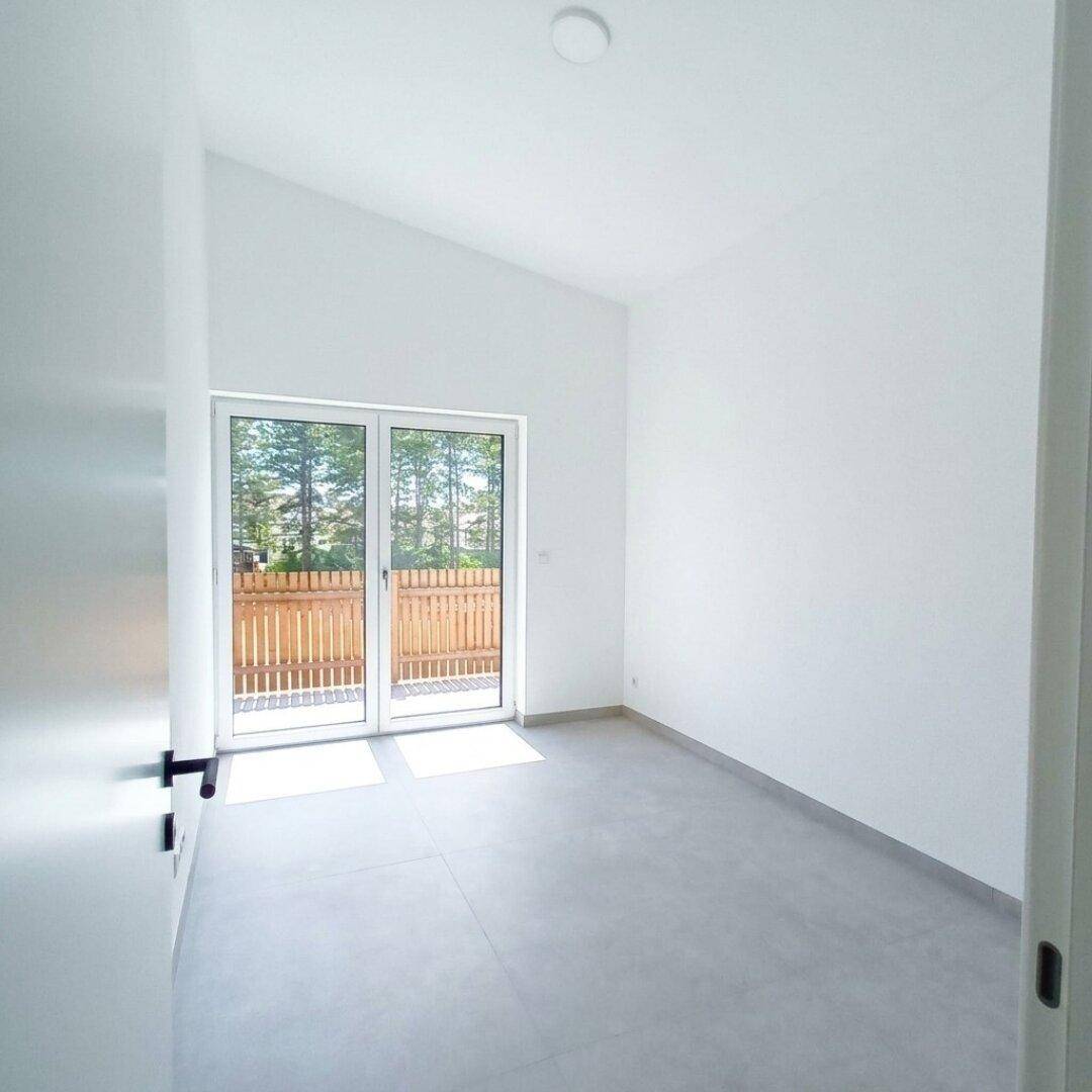 Schlafzimmer mit Zugang zu einem Balkon oder einer kleinen Terrasse und schrägen Decken.