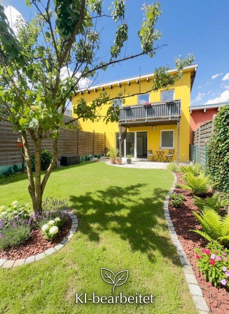 Gepflegter Garten mit Rasenfläche und Pflanzen vor einem gelben Haus mit Balkon und Terrasse.
