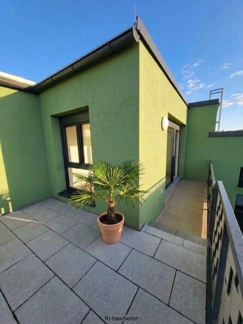 Sonniger Balkon mit Fliesenboden und einer kleinen Palme, ideal zum Entspannen im Freien.