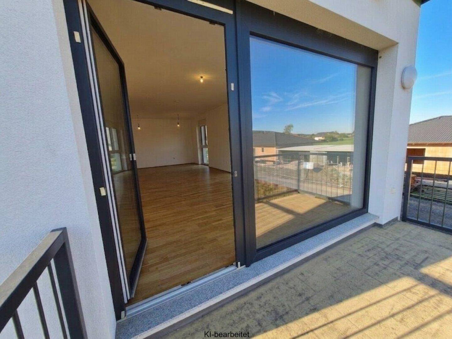 Helles Wohnzimmer mit Holzboden und direktem Zugang zu einem Balkon mit Weitblick.