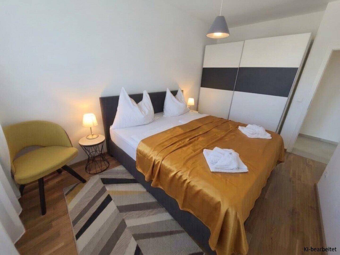 Helles Schlafzimmer mit Doppelbett, Nachttischen und großem Kleiderschrank.