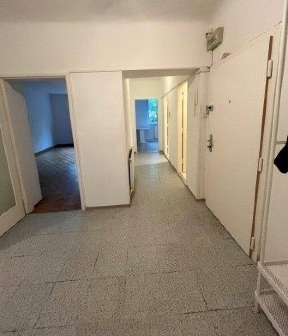 Geräumiger Flur mit Fliesenboden und Zugang zu verschiedenen Zimmern der Wohnung.