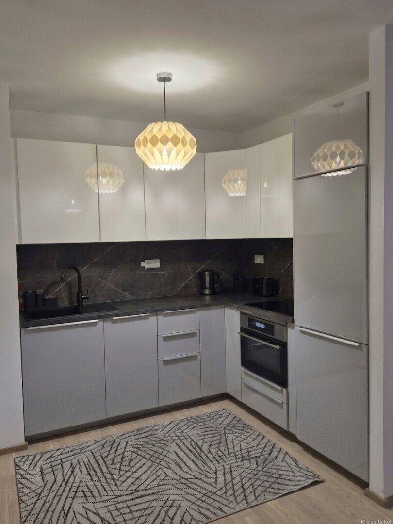 Moderne Einbauküche mit weißen und grauen Hochglanzfronten, ausgestattet mit Backofen und Induktionskochfeld.