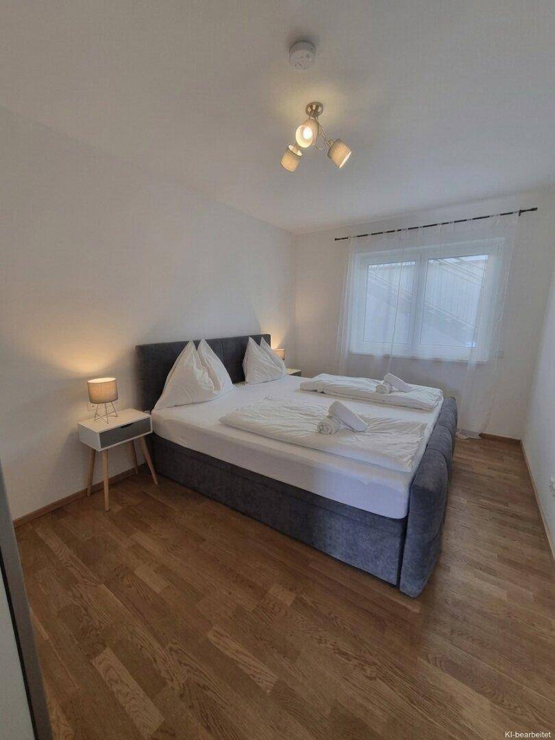 Gemütliches Schlafzimmer mit Doppelbett, Nachttischen und hellem Holzboden.