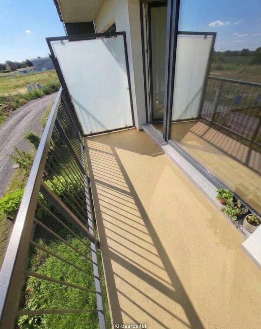 Schmaler Balkon mit Milchglas-Seitenwänden und Blick ins Grüne, ideal für sonnige Stunden.