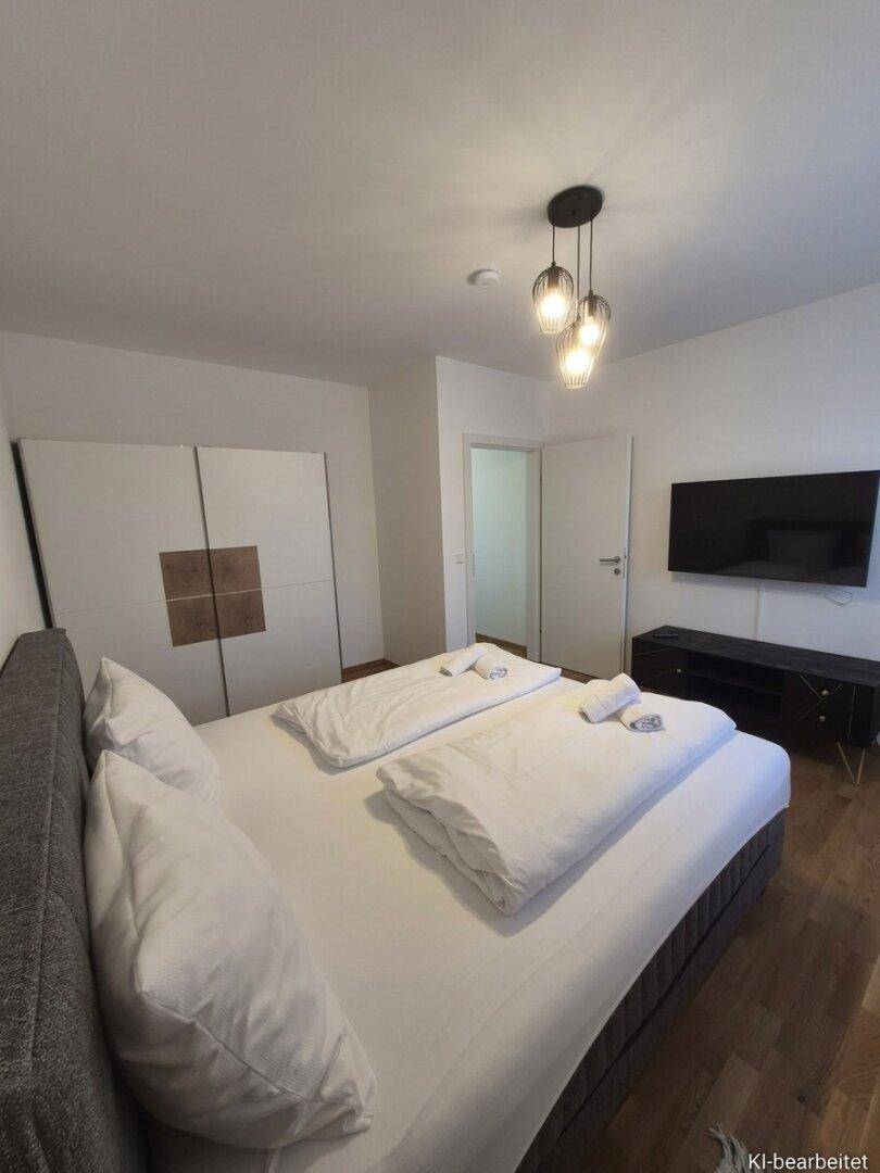Geräumiges Schlafzimmer mit großem Bett, modernem Kleiderschrank und Holzboden.