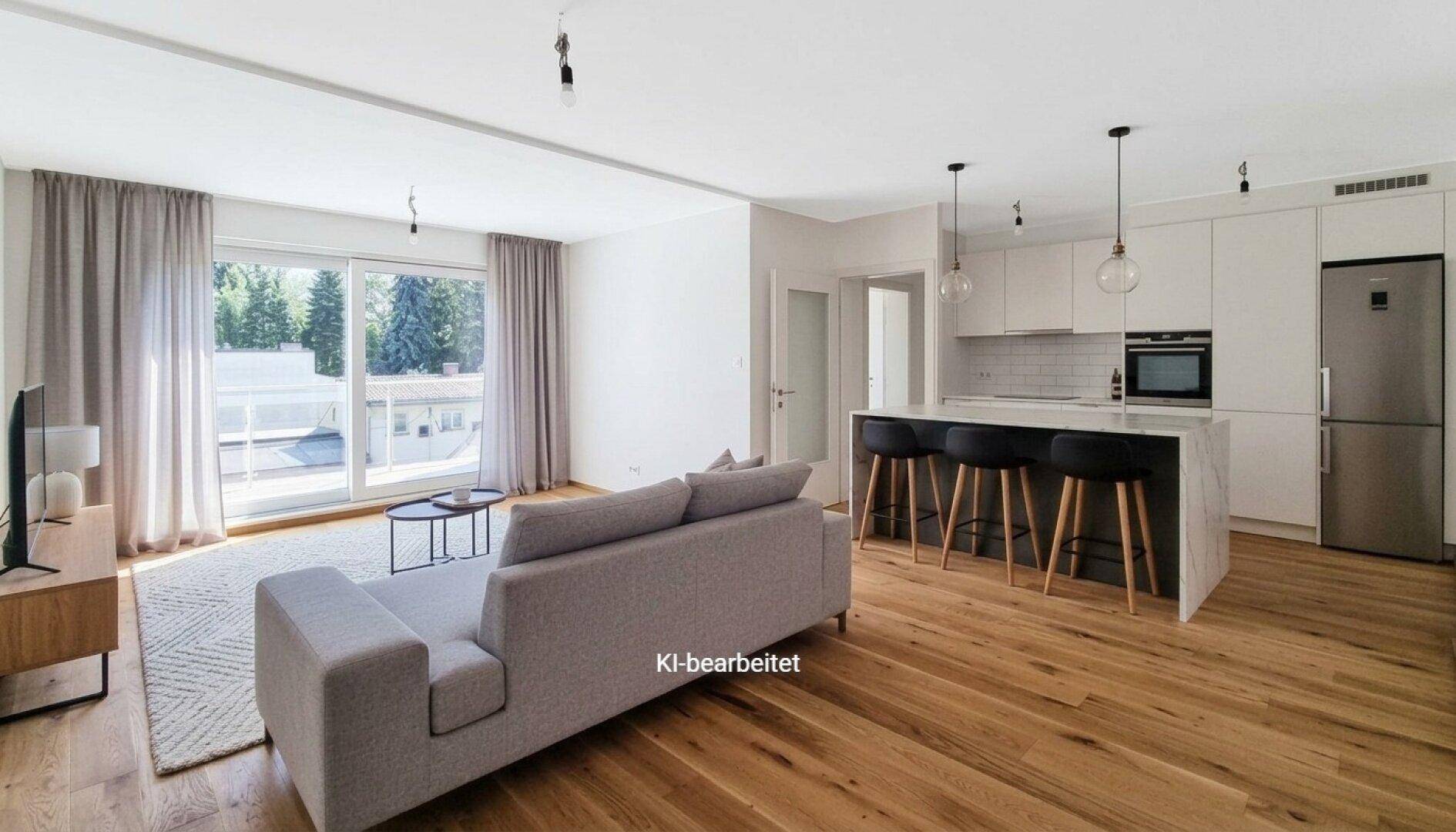 Helles, offenes Wohnzimmer mit integrierter Küche, Holzboden und Zugang zu einem Balkon.