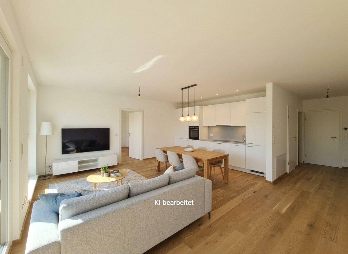 Offener Wohn- und Essbereich mit integrierter moderner Küche und hochwertigem Holzboden.