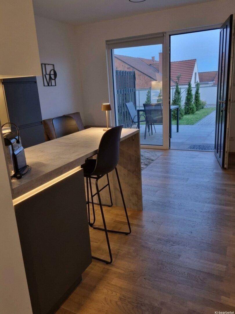Moderne Kücheninsel mit Barhockern und direktem Zugang zur Terrasse.