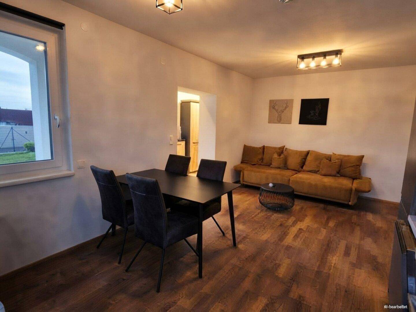 Moderner Wohn-Essbereich mit Holzboden, Esstisch und bequemer Couch.