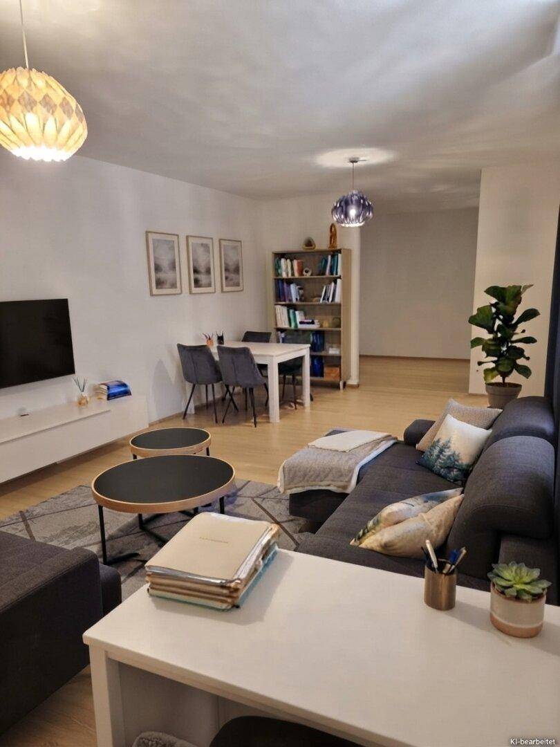Gemütlicher Wohnbereich mit großem Sofa, Couchtischen und einem Essbereich im Hintergrund.