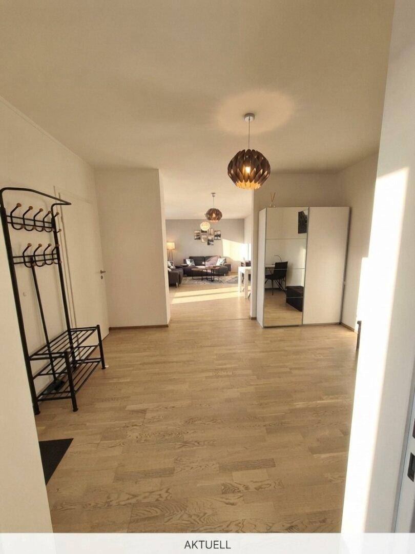 Langer Flur mit Garderobe und Spiegel, der zu den verschiedenen Räumen der Wohnung führt.