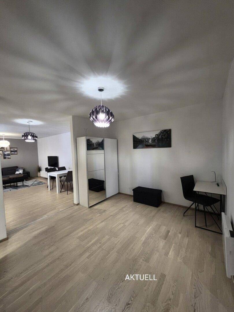 Geräumiges Arbeitszimmer mit hellem Holzfußboden und einem modernen Schreibtischbereich.