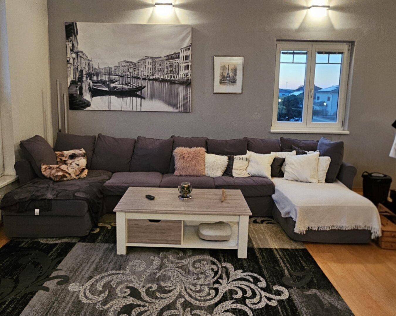 Gemütliches Wohnzimmer mit großem Ecksofa und stilvoller Dekoration.