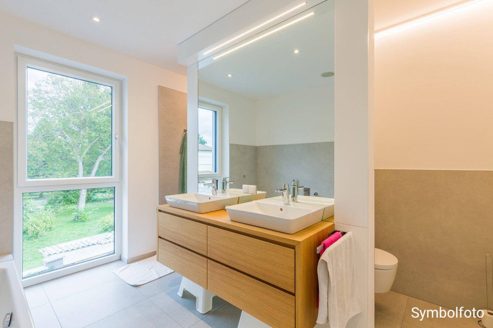 Helles Badezimmer mit Doppelwaschbecken, großem Spiegel und wandhängendem WC.