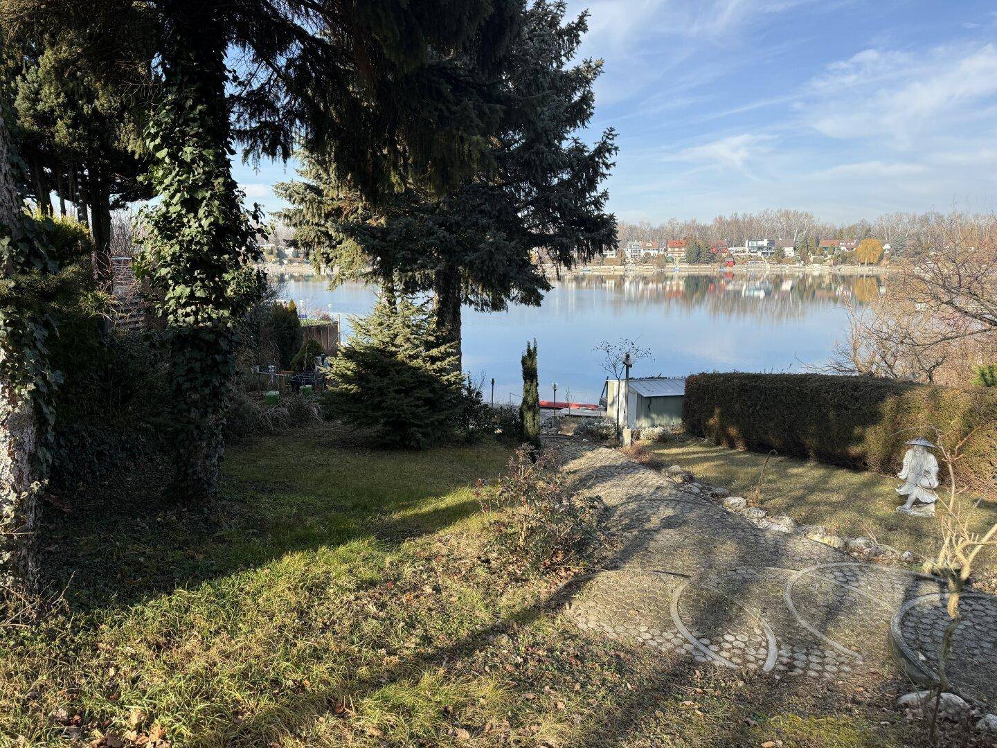 Gepflegter Garten mit altem Baumbestand und direktem Zugang zum Seeufer.