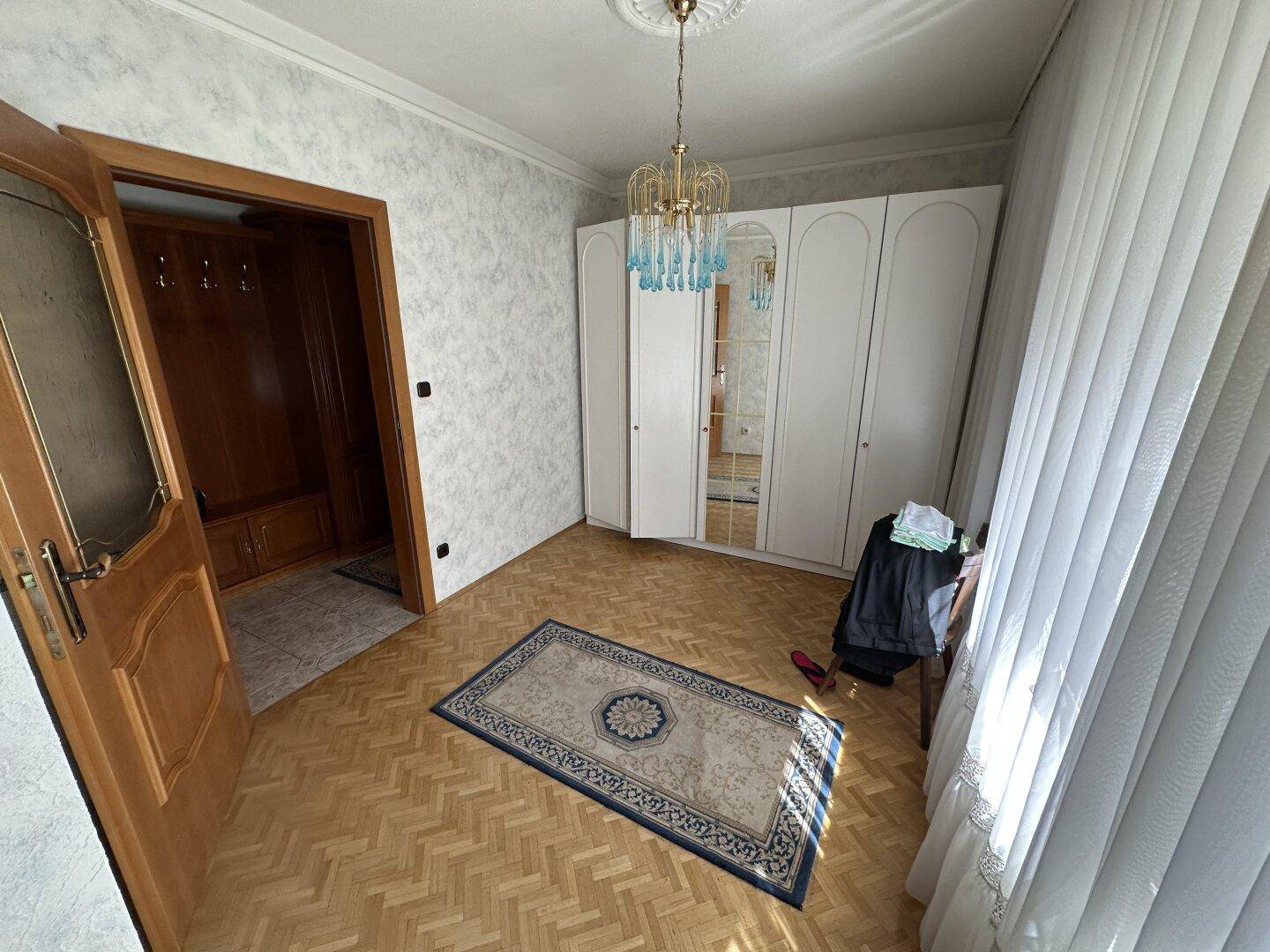 Kleiner Raum oder Flur mit weißem Kleiderschrank, Parkettboden und Garderobe.
